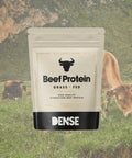 Busta da 500g di Beef Protein Grass Fed Carnivore Company, proteina idrolizzata del manzo al naturale, con mucche al pascolo sullo sfondo verde