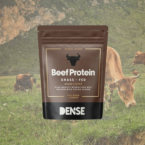 Busta marrone da 500g di Beef Protein Grass Fed gusto cacao del brand Carnivore Company, con mucche al pascolo su prato verde sullo sfondo — proteine del manzo grass fed idrolizzate animal-based