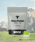 Confezione di proteine Whey grass fed neutre bio Carnivore Company con sfondo di montagne alpine