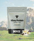 Confezione di proteine Whey grass alla vaniglia fed Carnivore Company con aroma vaniglia, sullo sfondo delle Alpi.